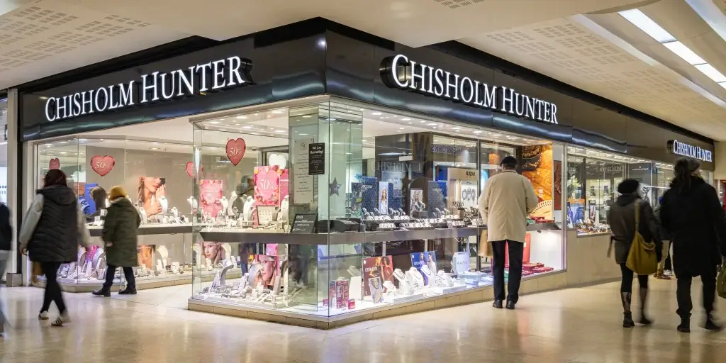 Exterior view of the Chisholm Hunter jewelry store, showcasing displays of jewelry and shoppers browsing through the storefront.