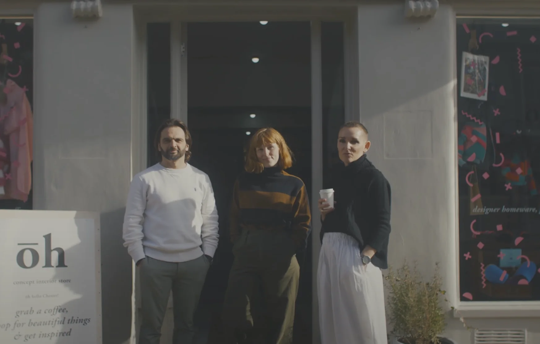 Three people standing outside the Openhome Group Chester on a sunny day.