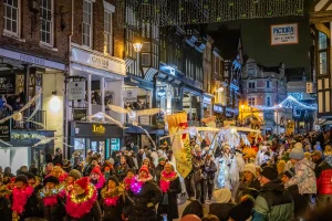 Crowds of People talking part in a parade in Chester