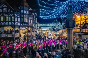 Crowds of People talking part in a parade in Chester