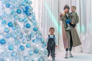 A woman and two children next to a christmas tree