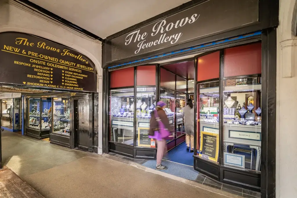 Entrance of The Rows Jewellery shop showcasing quality jewelry with a customer walking inside, while another browses outside.