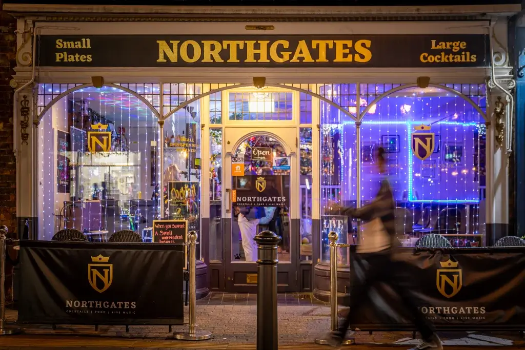 The lively exterior of Northgates bar features patrons enjoying drinks, showcasing a vibrant atmosphere in a bustling street setting.
