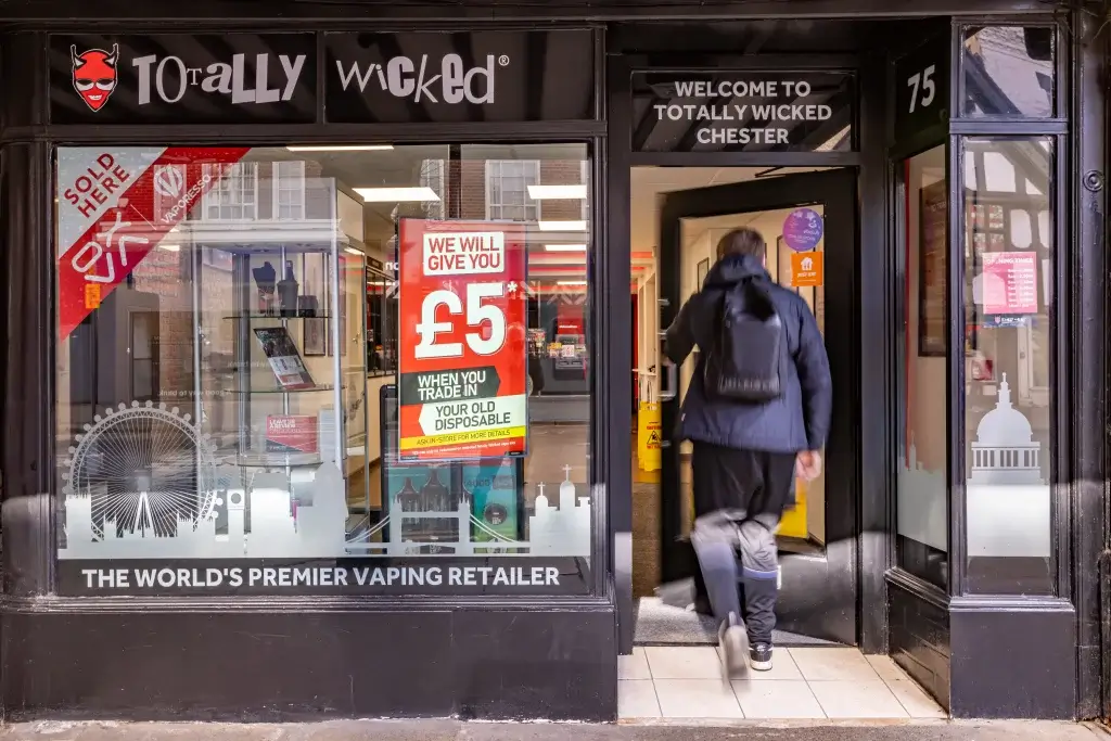 A person enters the Totally Wicked vape shop in Chester, following a sign advertising a £5 trade-in offer for old disposable vapes.