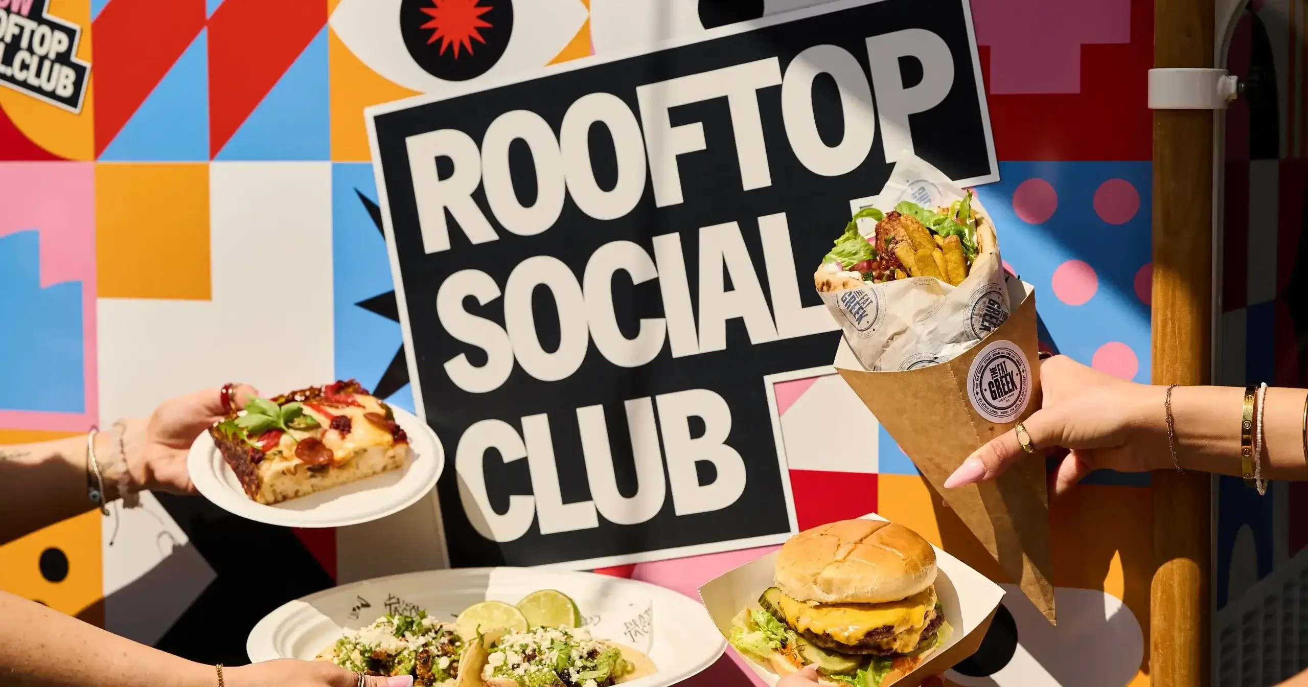 A colorful food display featuring pizza, tacos, and a burger, set against a vibrant "Rooftop Social Club" backdrop.
