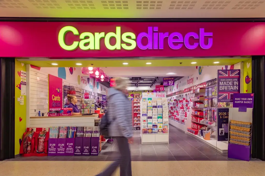 A colorful store entrance labeled "Cards direct" showcasing various greeting cards, gift wraps, and party supplies.