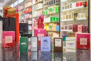 Perfume sample boxes on a speckled counter with large pink La Bomba gift boxes and a pink butterfly-shaped bottle.
