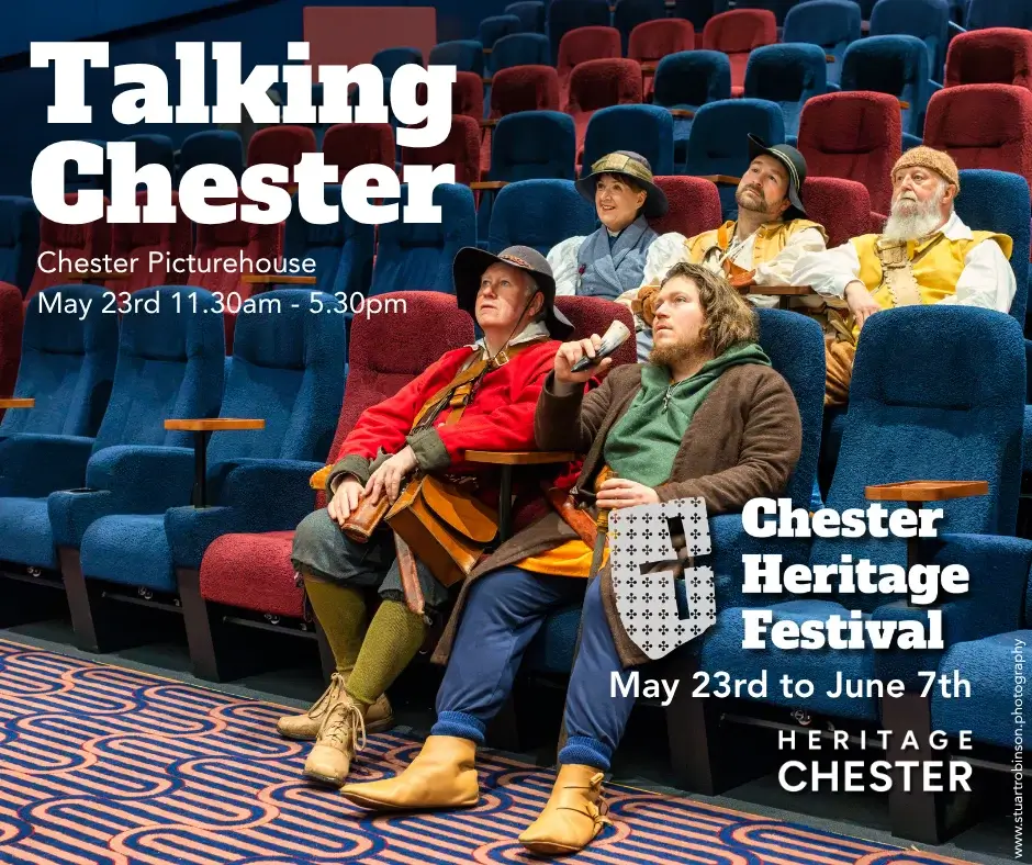 Five people in historical costume seated in a modern cinema, watching ahead; text advertising Chester Heritage Festival.